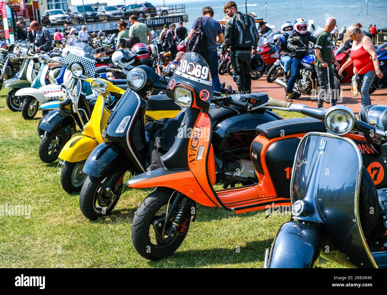 Classic and retro scooters parked on the green in the coastal town of