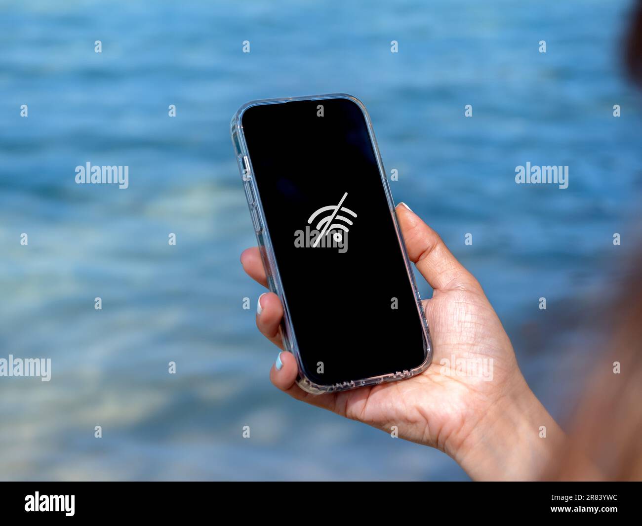 No internet connection technology concept. No signal service at the beach. Wi-Fi network offline sign on mobile smart phone display screen on woman's Stock Photo