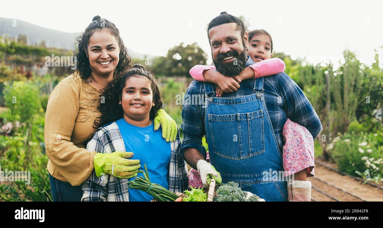 Indian family holding basket full of organic vegetables from house ...