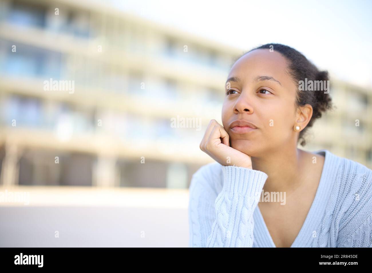 Black woman thinking looking away in the street Stock Photo