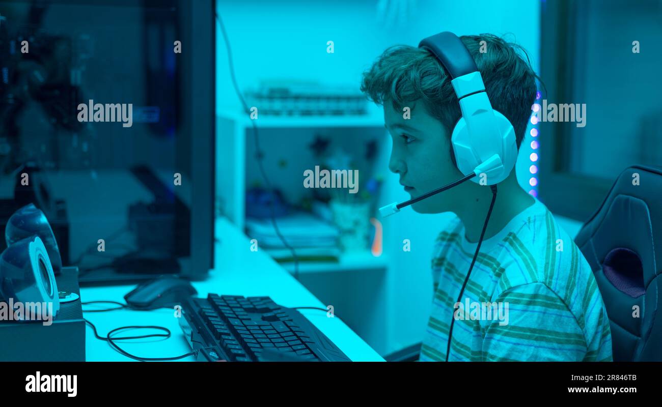 Teenager with headphones playing with the pc. Gaming concept Stock Photo