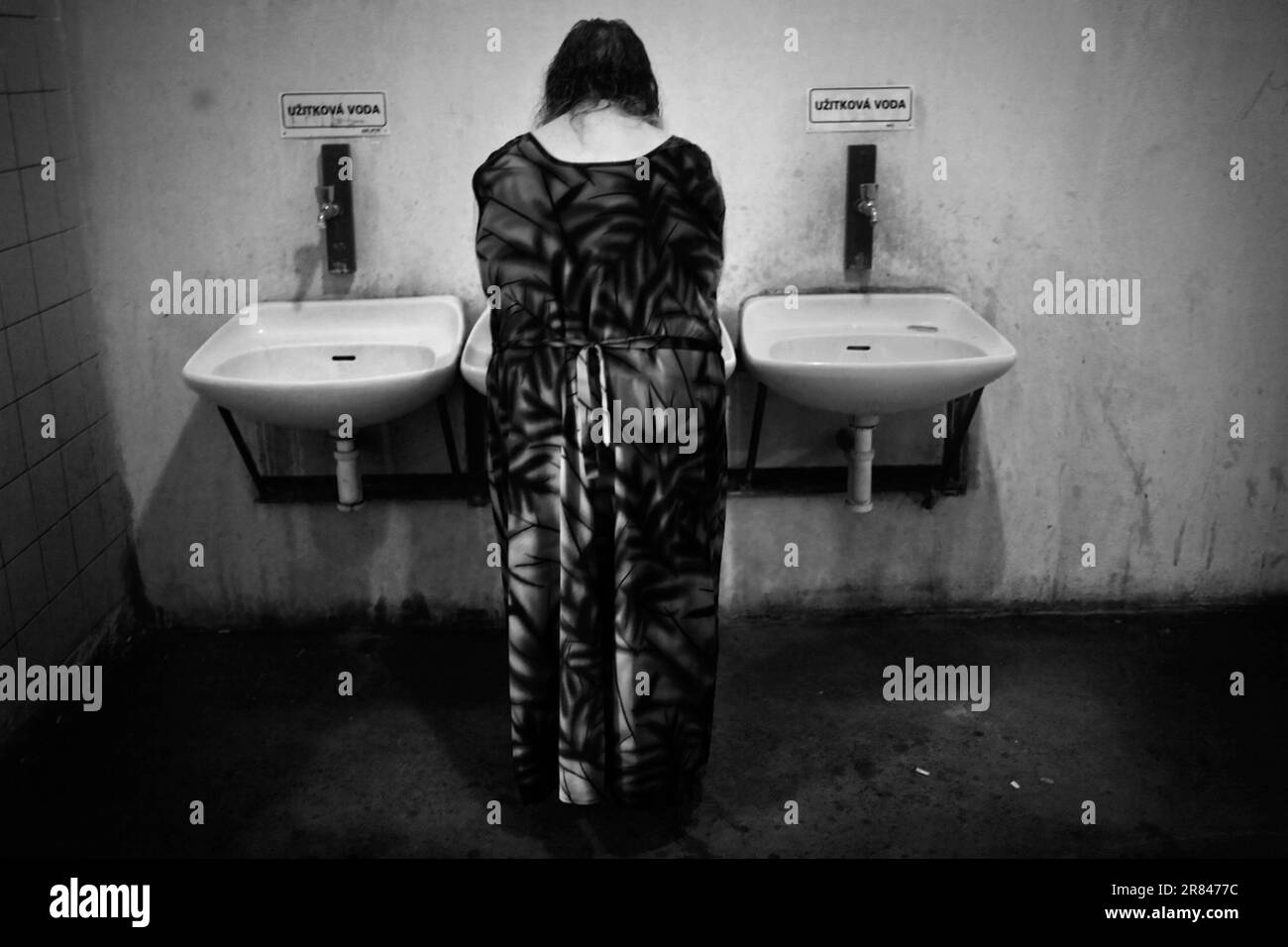 a-woman-washed-her-hands-in-the-middle-of-three-sinks-at-her-make-shift
