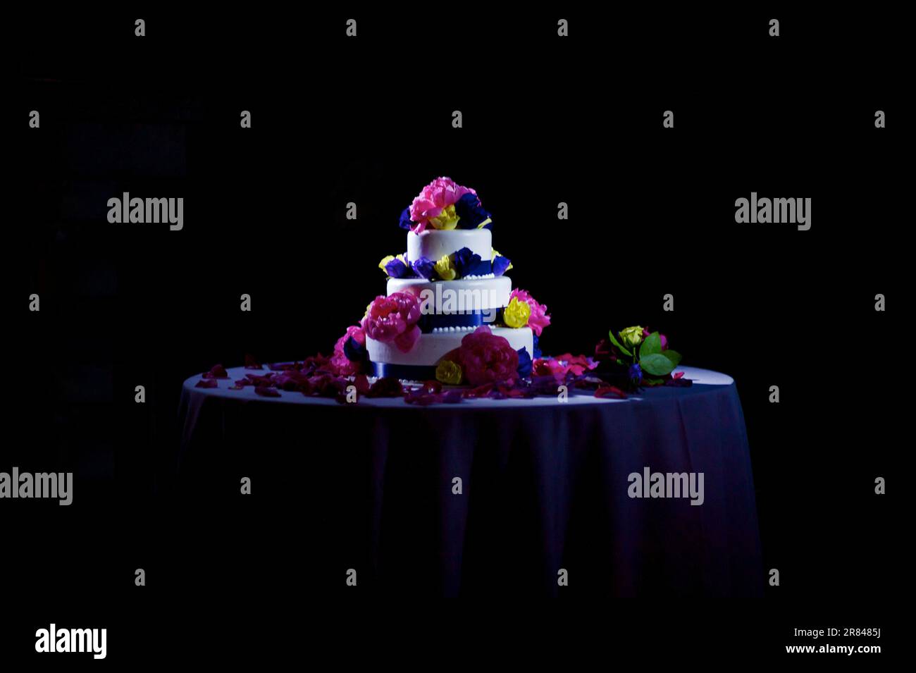 A wedding cake sits on a table during a wedding reception. Stock Photo
