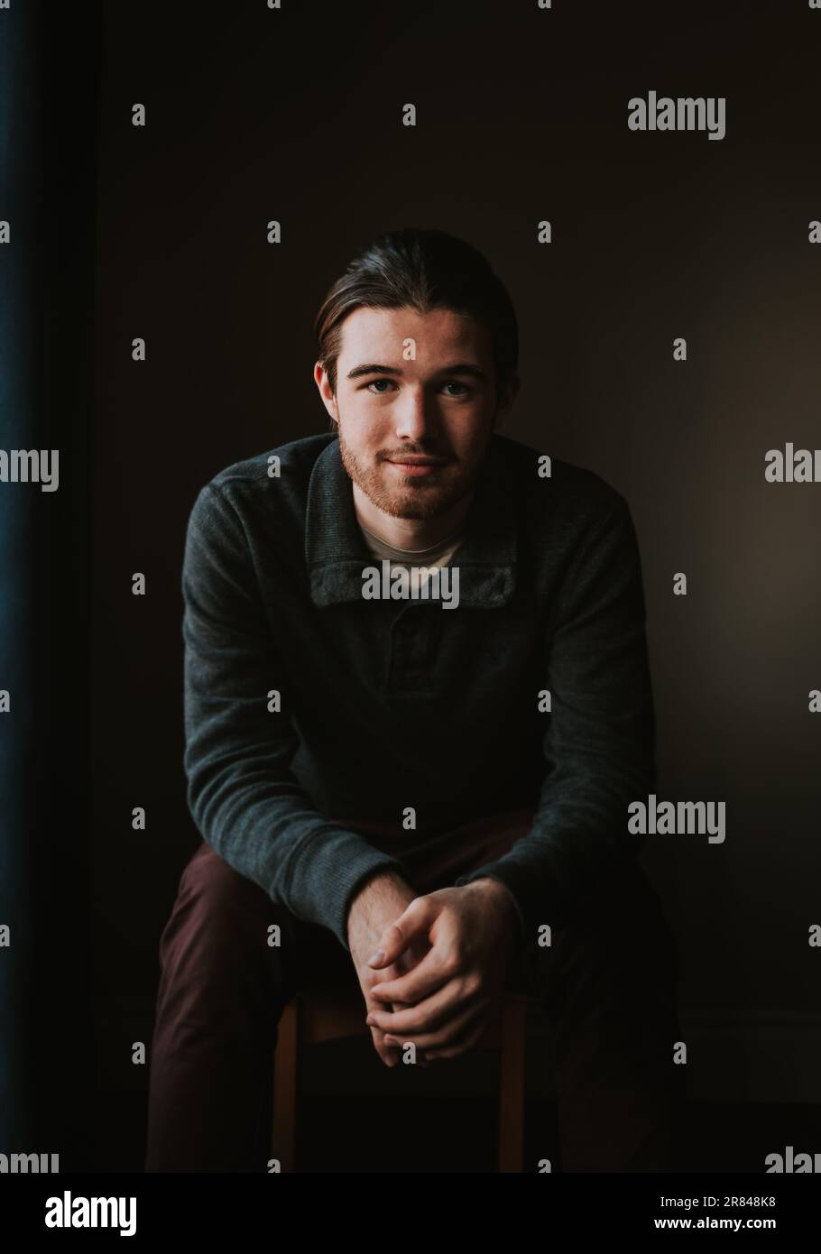 Young millenial man sitting hi-res stock photography and images - Alamy