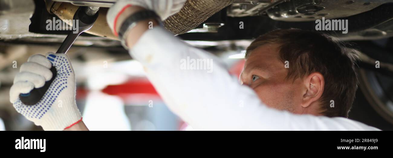Auto mechanic checks running gear of car at service station Stock Photo ...