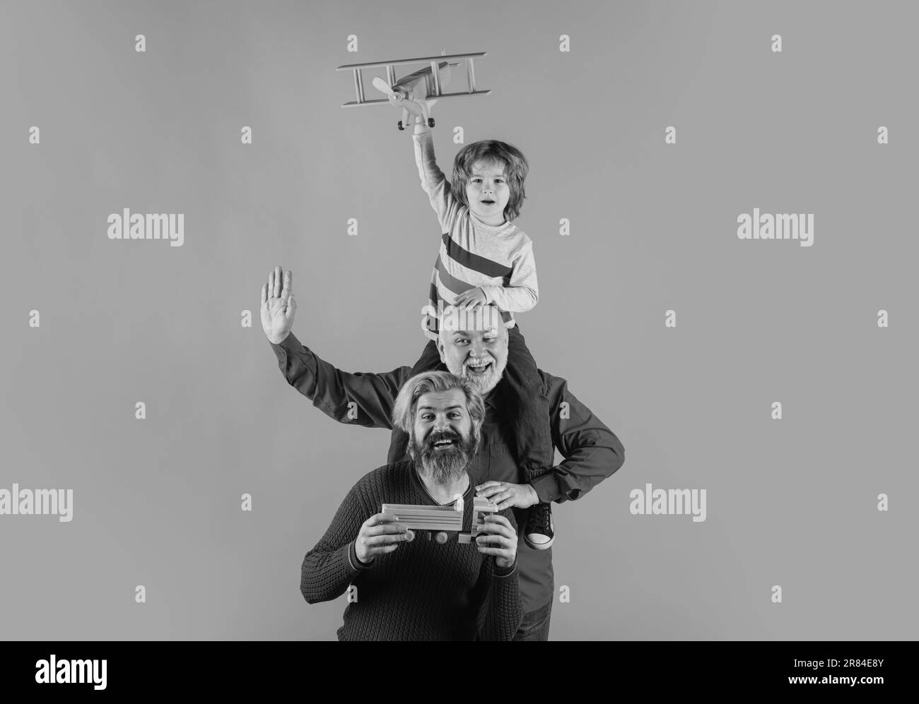 Grandfather father and son playing with toy plane. Happy man family