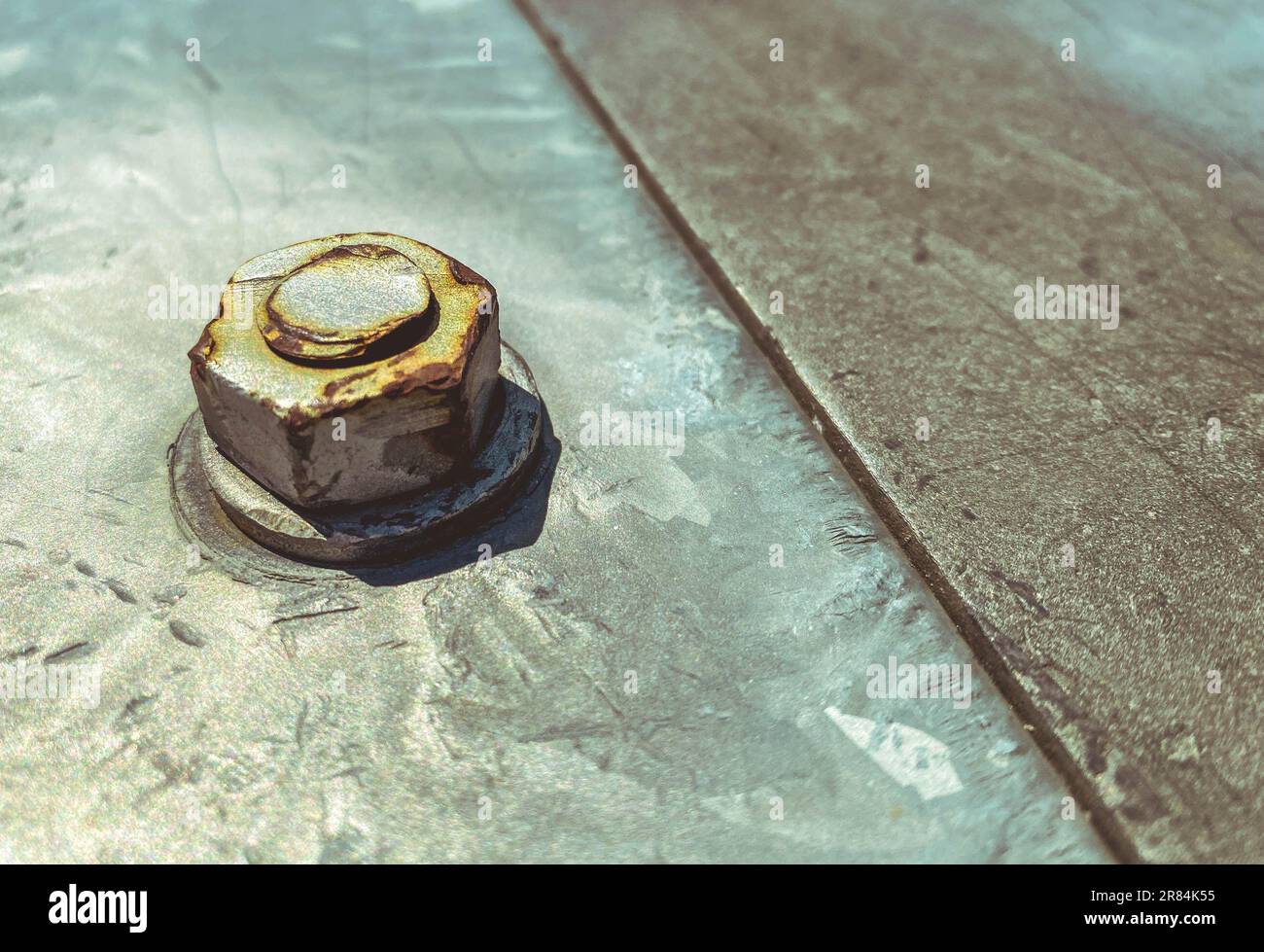 metal texture. a large screw is screwed on a gray sheet of metal