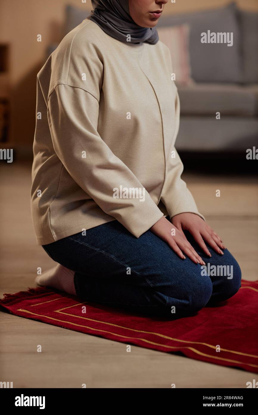 Cropped shot of young woman in beige pullover and blue jeans saying ...