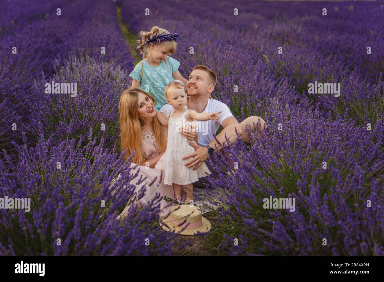 Happy family, father and mother with two daughters on a picnic at lavender field Stock Photo