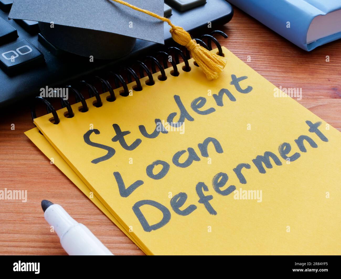student-loan-deferment-inscription-near-calculator-and-graduation-cap