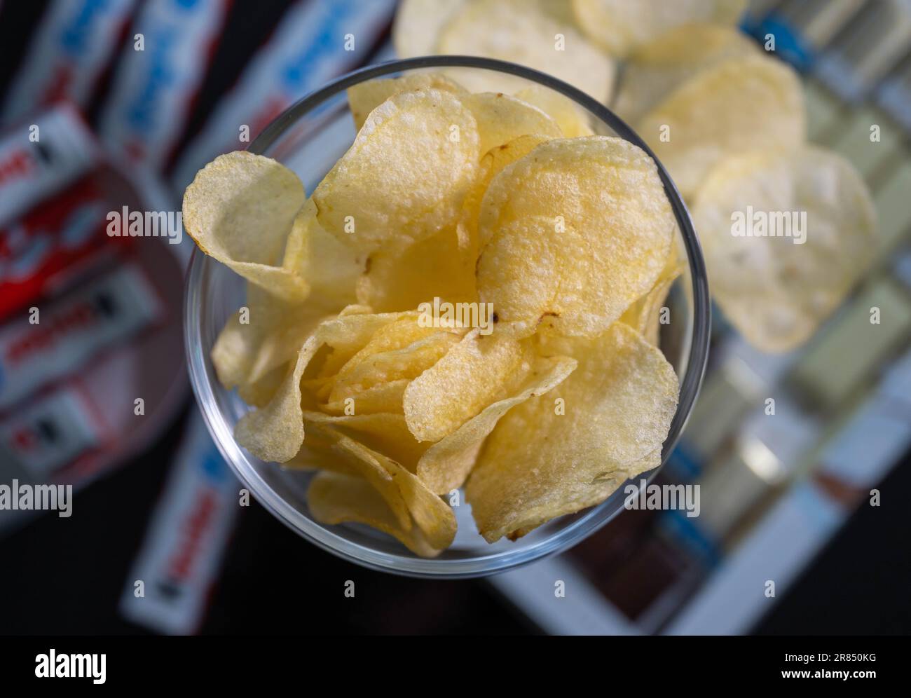 PRODUCTION - 16 June 2023, Saxony, Leipzig: ILLUSTRATION - A bowl of potato chips stands on a coffee table. Photo: Hendrik Schmidt/dpa Stock Photo