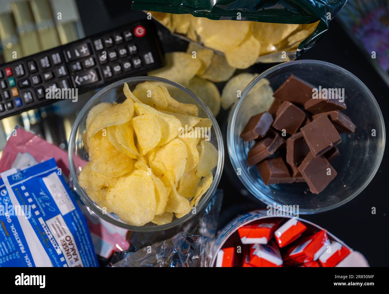 PRODUCTION - 16 June 2023, Saxony, Leipzig: ILLUSTRATION - Bowls of chocolate and potato chips stand on a coffee table. Photo: Hendrik Schmidt/dpa Stock Photo