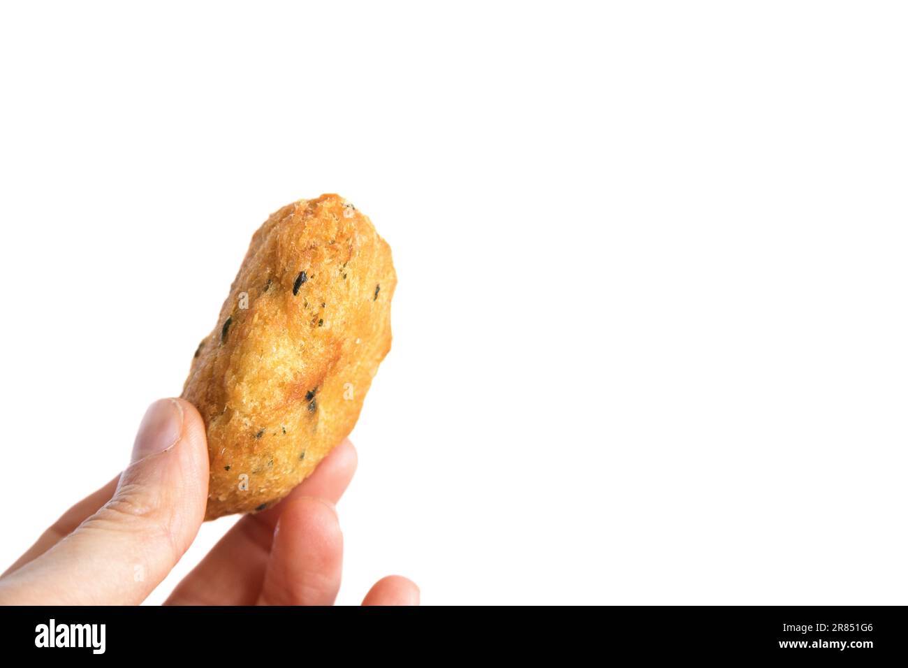 Cod dumpling, or 'bolinho de bacalhau', very famous in Portuguese gastronomy. Fried dumpling, fish, salted cod fritters. Hand holding cod fritter. Stock Photo