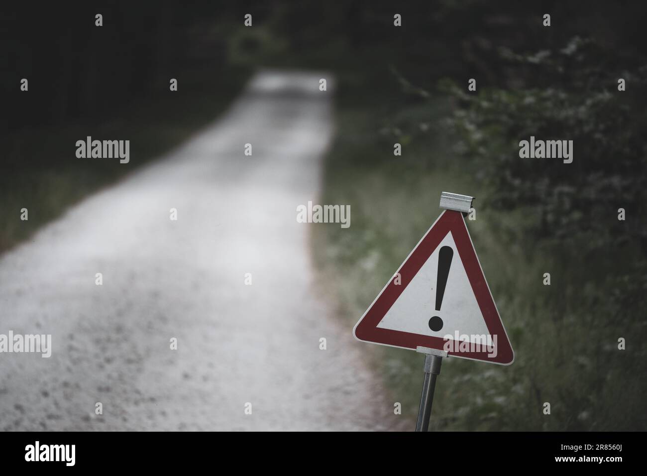 Road sign indicating other dangers on a forest road. Concept of some unknown circumstances and risk, a warning about liability and a call for caution. Stock Photo