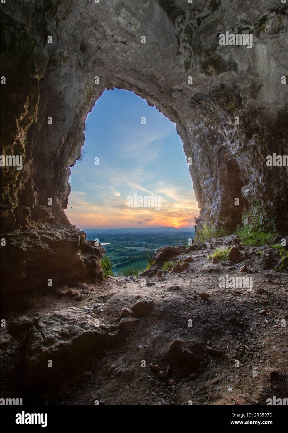 A vertical of sunset over a landscape seen from a cave Stock Photo - Alamy