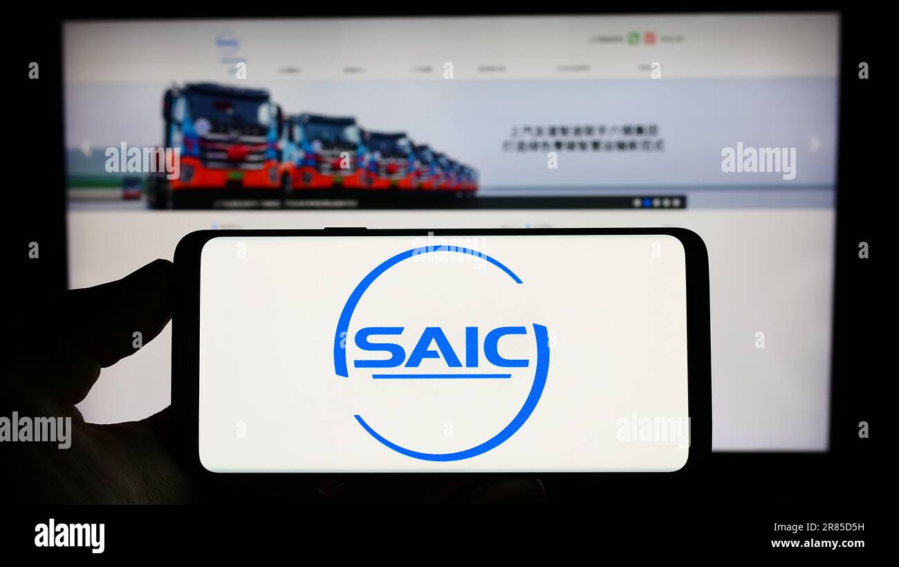 Person holding cellphone with logo of Chinese automotive company SAIC