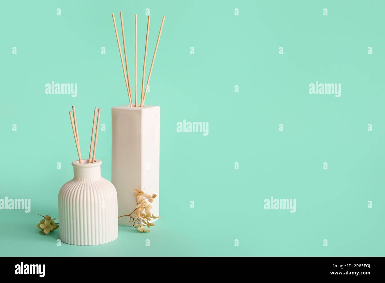 Bottles of reed diffuser and flowers on turquoise background Stock ...