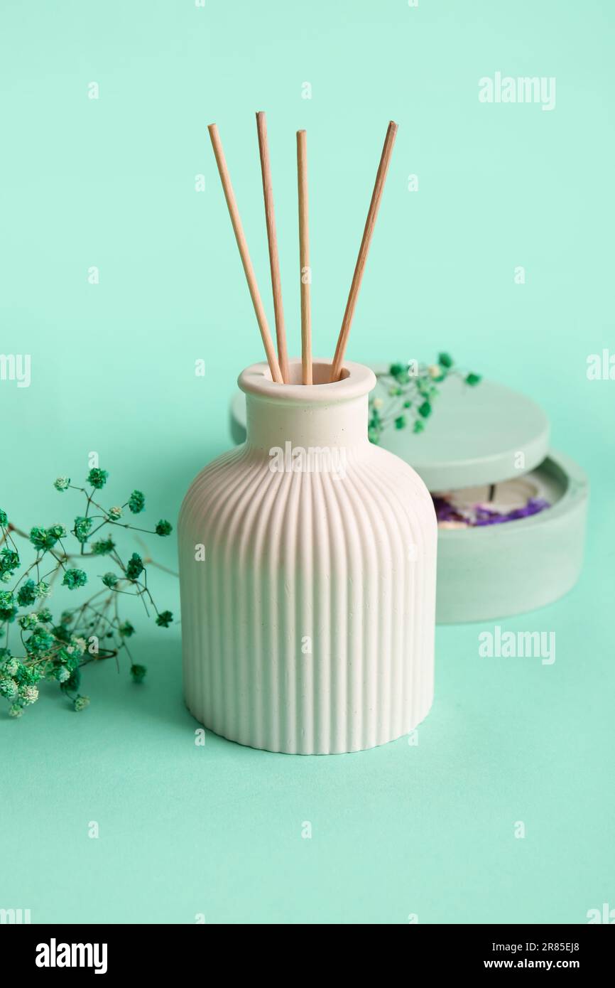 Floral reed diffuser and gypsophila flowers on turquoise background ...