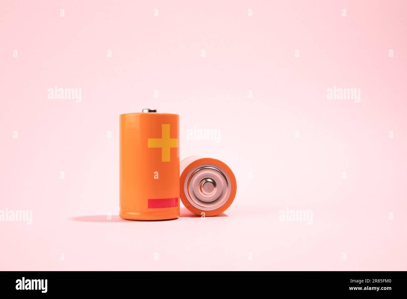 Orange battery on pink background, energy concept Stock Photo