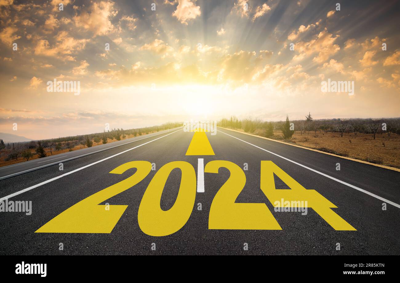 The word 2024 written on the highway. 2024 target indicated by arrow on empty asphalt road. Coming into the new year Stock Photo