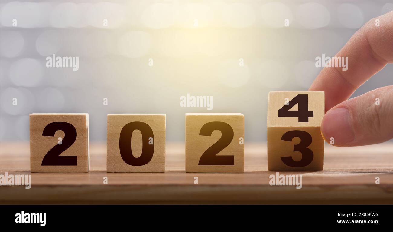 New year exchange concept. Man fingers with turning the calendar wooden