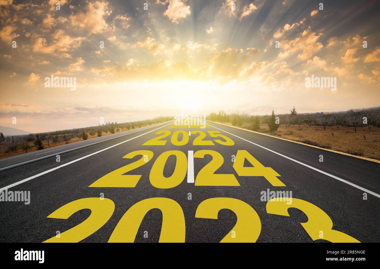 Starting the new year. Start line on asphalt road and 2024 going arrow on horizon. New year concept. Stock Photo