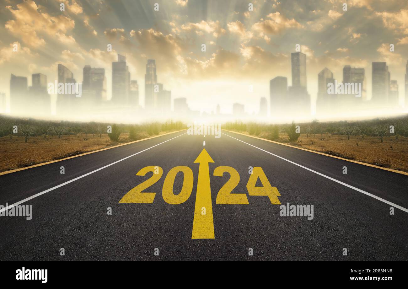 Year 2024 written on flat asphalt road. Empty road to city and sunrise
