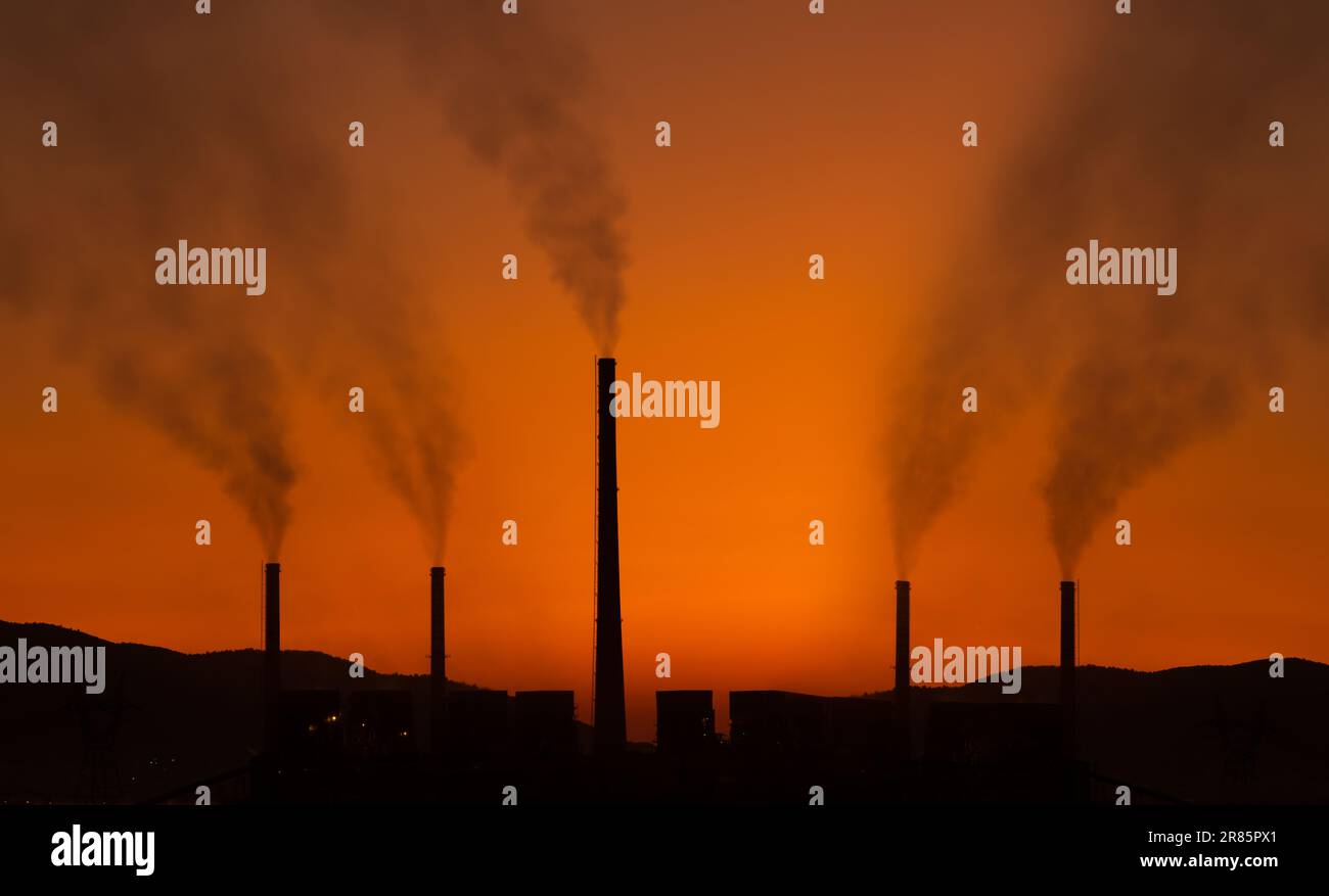 Environmental pollution concept. Silhouette of black smoke coming out of factory chimneys. Air pollution Stock Photo