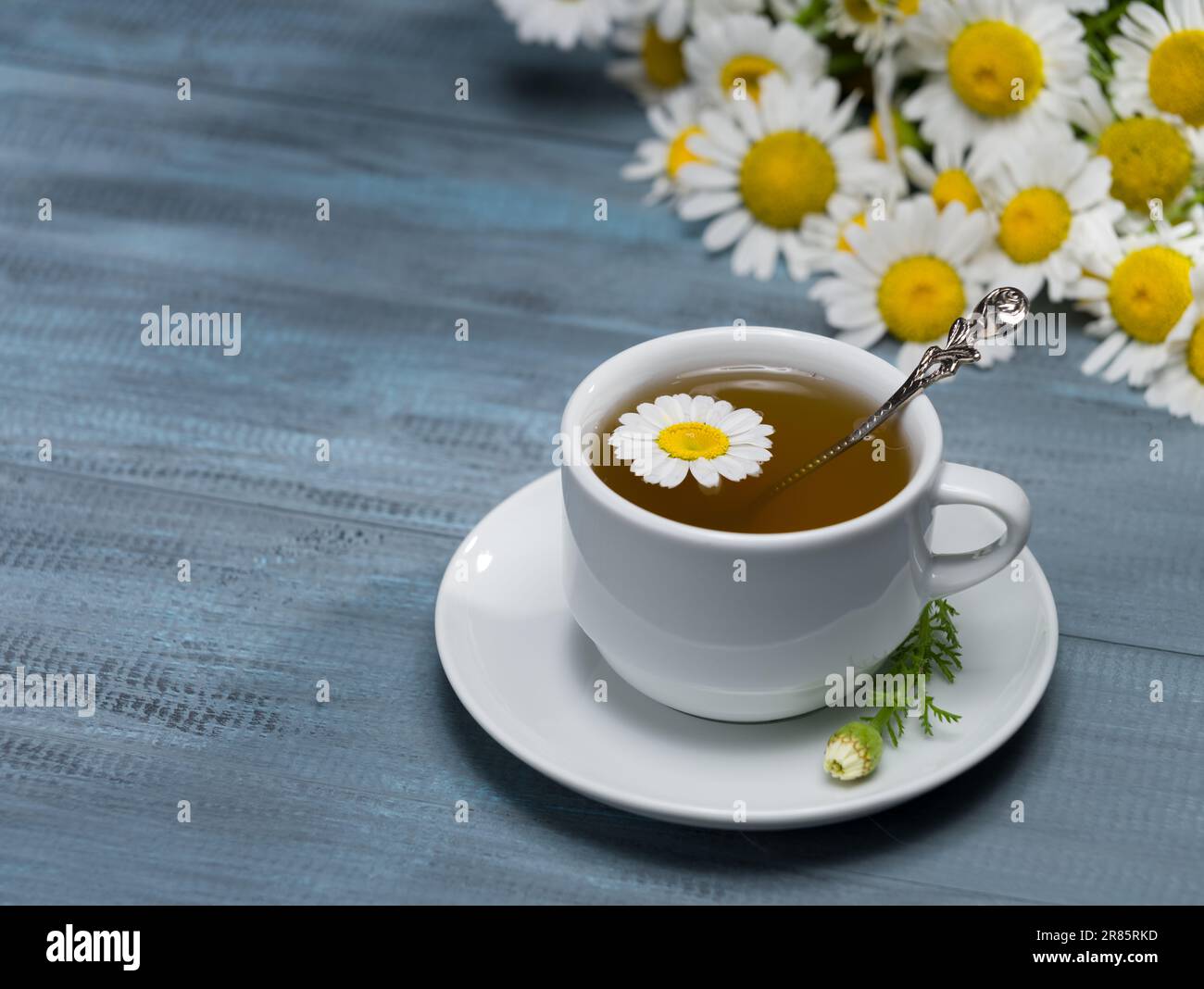 Cup of fresh chamomile tea on rustic table. Healthy teas concept Stock Photo