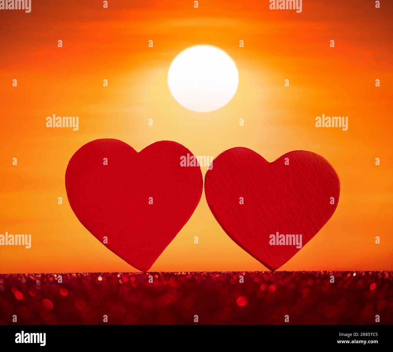Two hearts side by side with sunset background. Valentine's day concept. Stock Photo