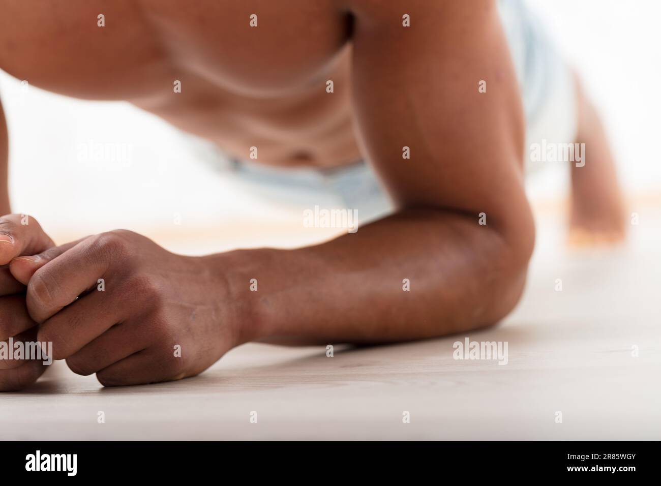 Nectorals Unrecognizable black man holds a stoic plank, elbows grounded. His ...