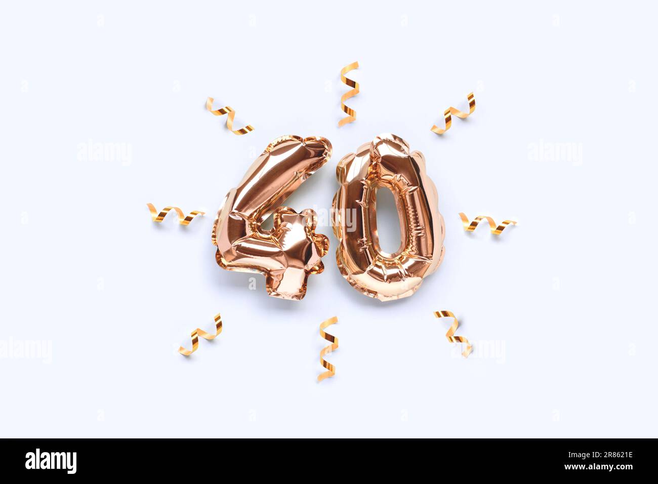 Number 40 gold inflatable balloons with ribbon confetti on a blue background. Stock Photo