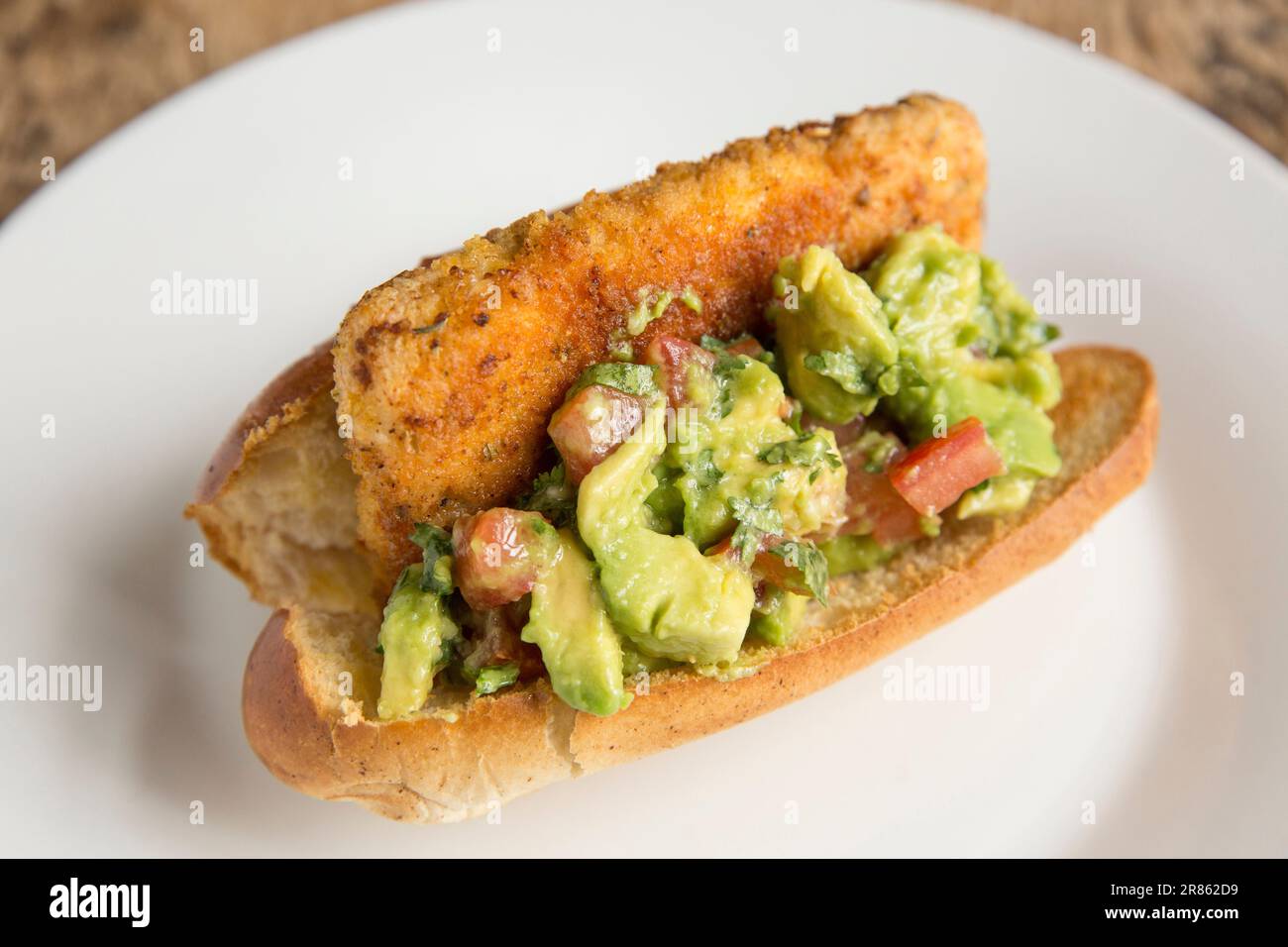 A fillet from a Smooth-hound, Mustelus mustelus, that was caught in the English Channel, that have been fried in breadcrumbs and served on a brioche b Stock Photo