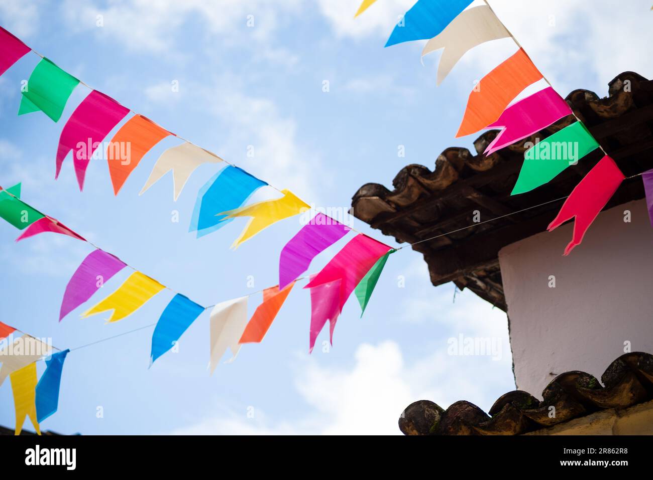Flags of different colors hanging from a rope. Decoration of Sao Joao ...