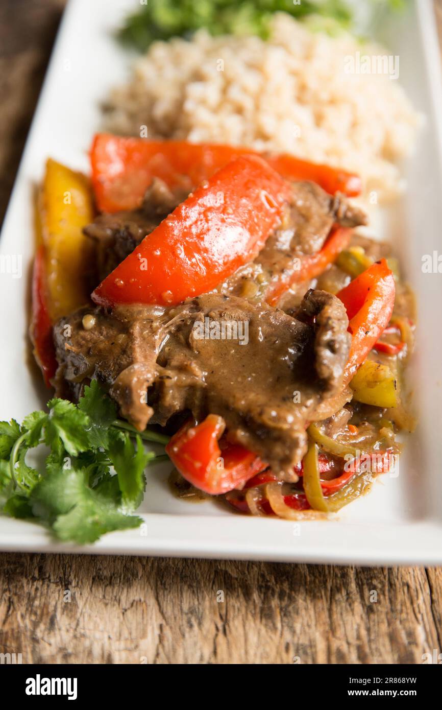 Slices of venison from a roe deer, Capreolus capreolus, that have been cooked with peppers in black bean sauce. England UK GB Stock Photo
