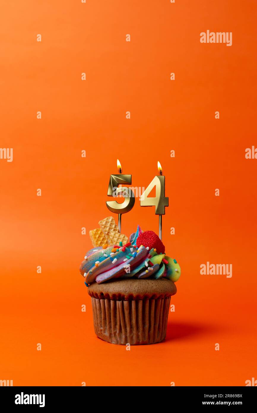 birthday cake with number 54 - cupcake on orange background with birthday candles Stock Photo