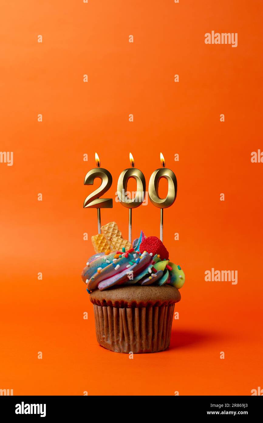 birthday cake with number 200 - cupcake on orange background with birthday candles Stock Photo