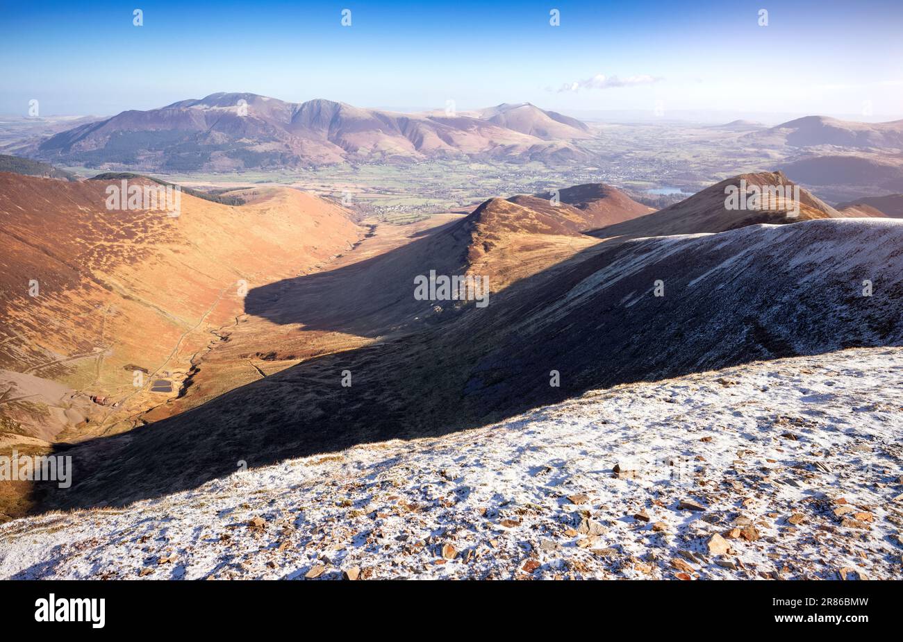 Looking down on to Coledale Beck from the summit of Crag Hill with Skiddaw and Blencathra in the distance in winter in the English Lake District, UK. Stock Photo