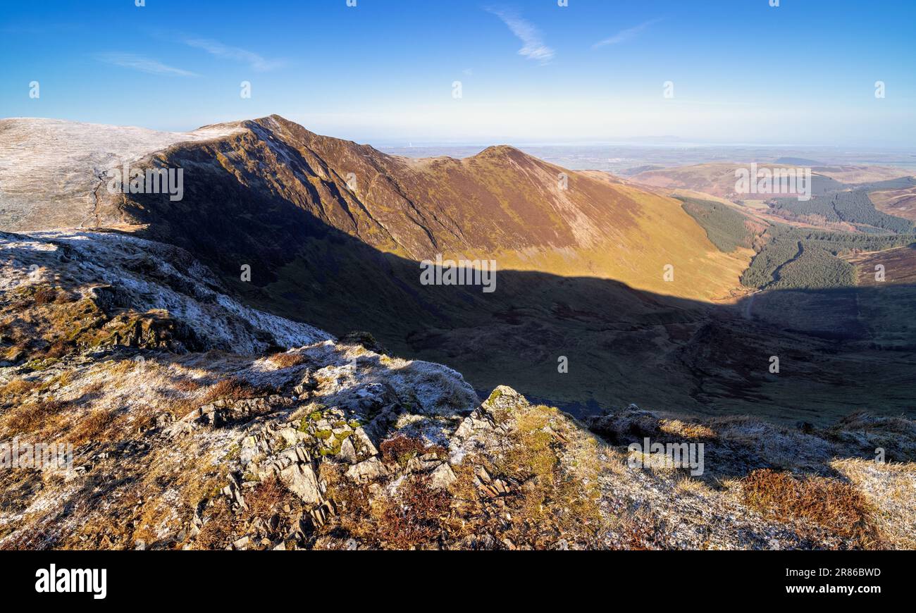 The summit of Hopegill Head on the left above Hobcarton Crag and Hobcarton in the valley below in winter in the English Lake District, UK. Stock Photo