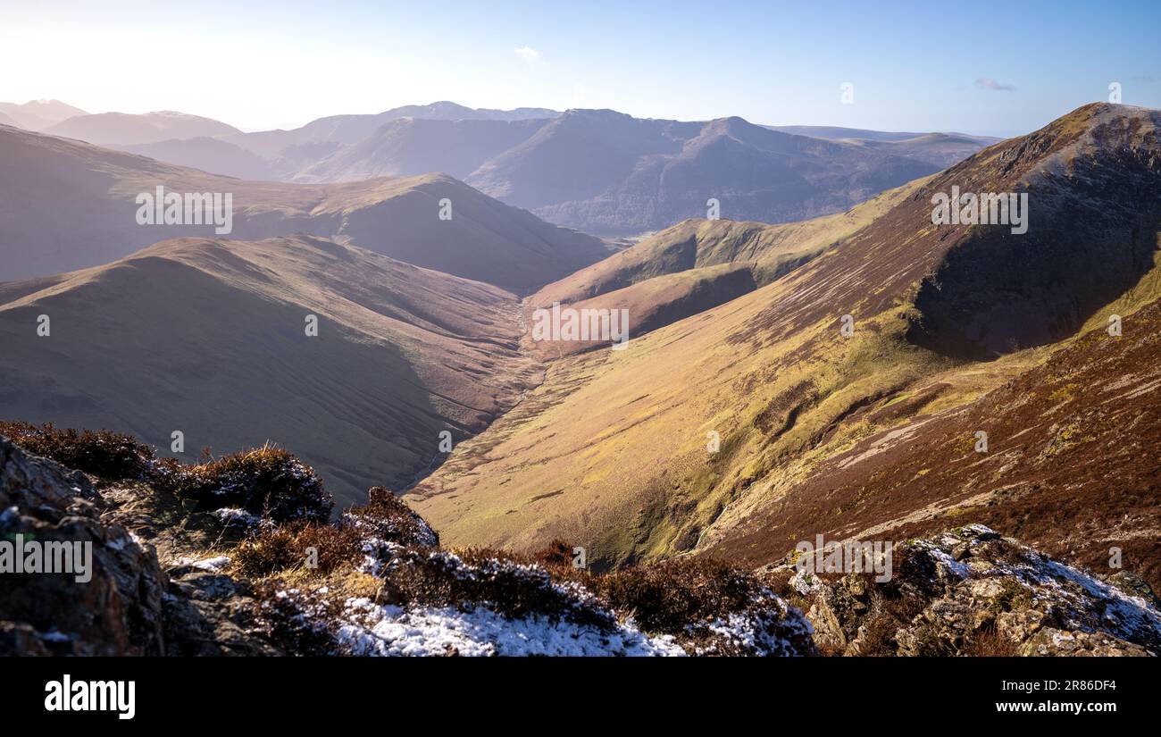 The valley of Sail Beck below the summit of Knott Rigg and High Snockrigg with High Crag, High Stile and Red Pike in the distance in winter in the Eng Stock Photo