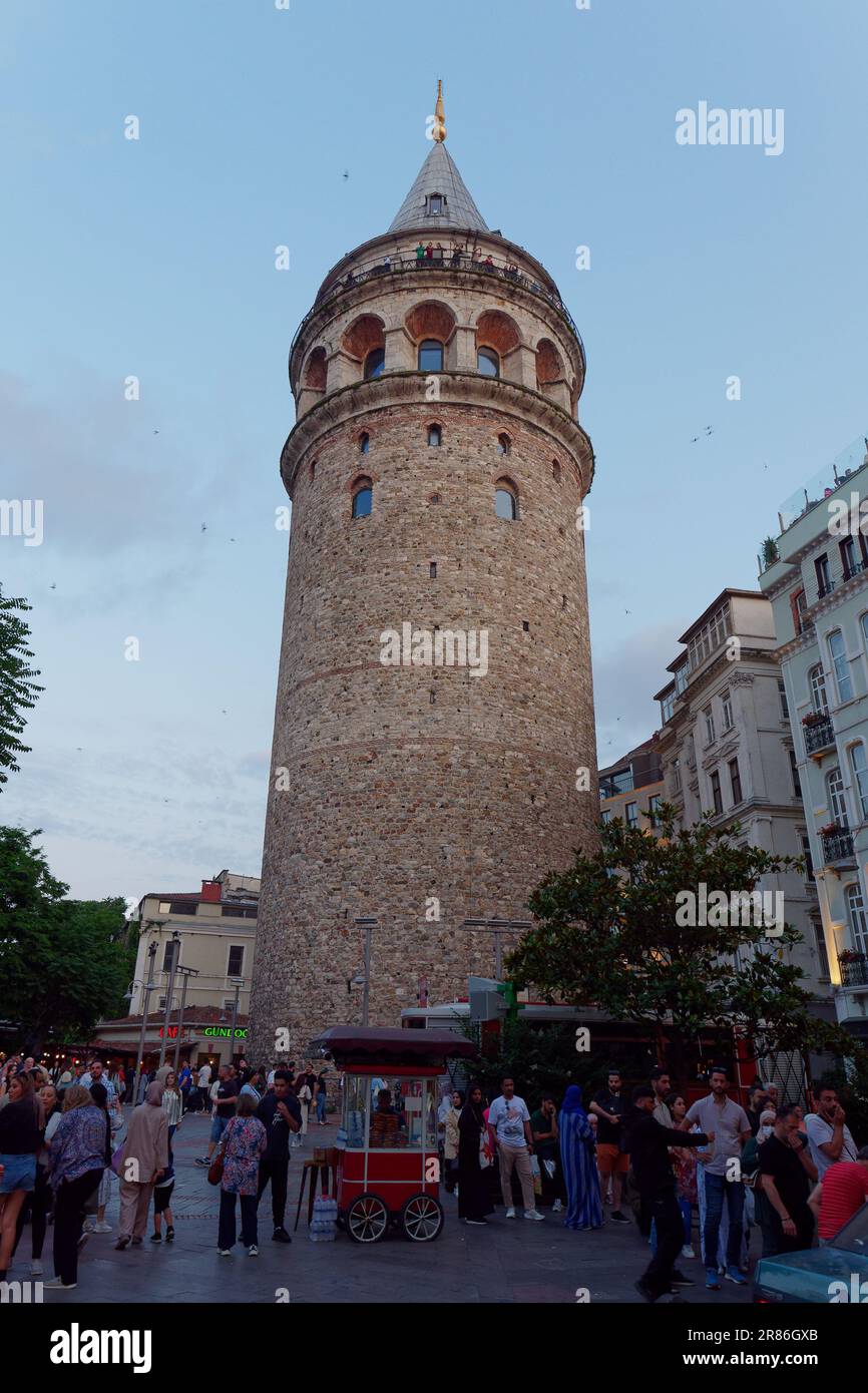 Tourists beneath the Galata Tower in the evening in Istanbul, Turkey Stock Photo