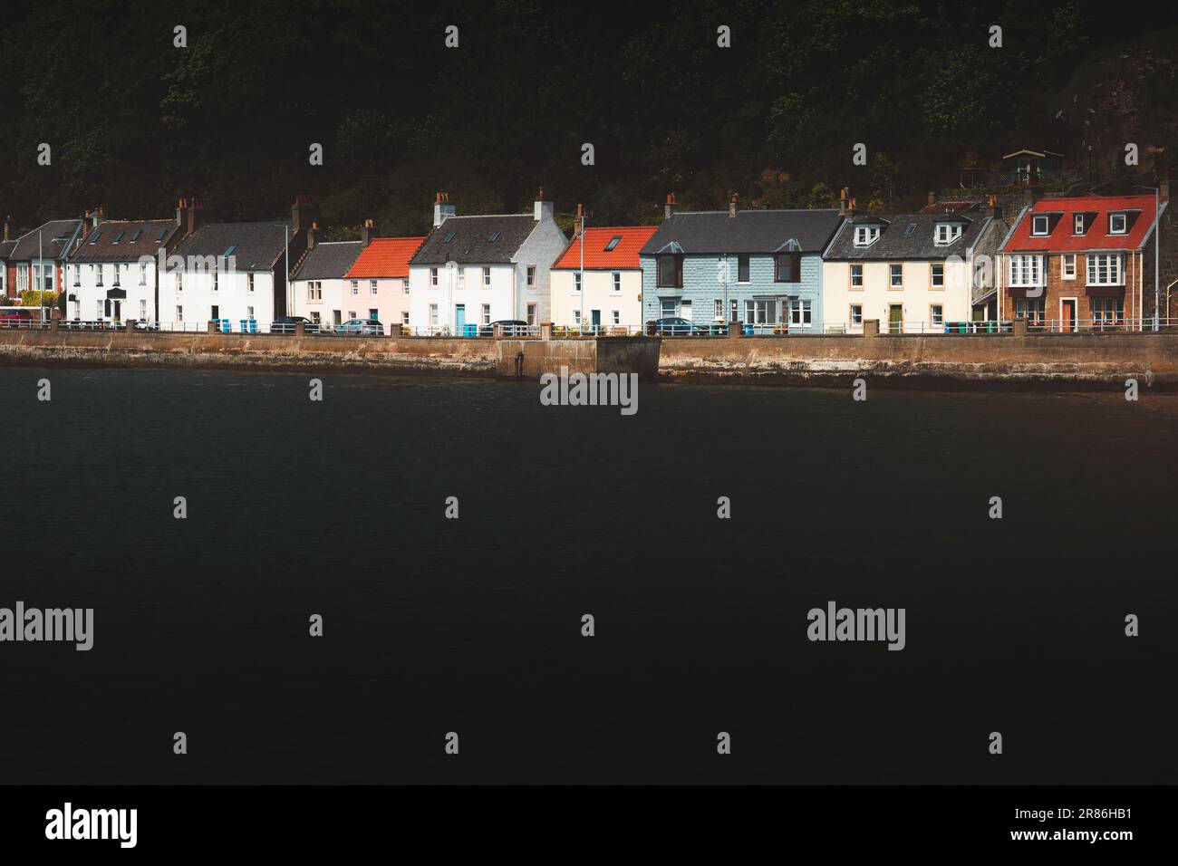 Dark, moodt, atmospheric scenery of colourful row of waterfront homes