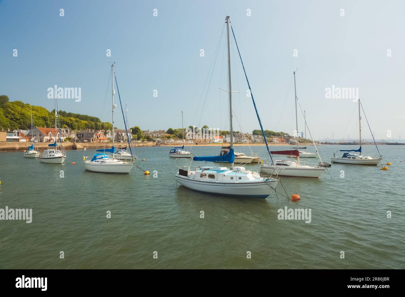 Sailboats anchored in the Firth of Forth on a sunny summer day at the coastal seaside village of Limekilns, Fife, Scotland, UK. Stock Photo