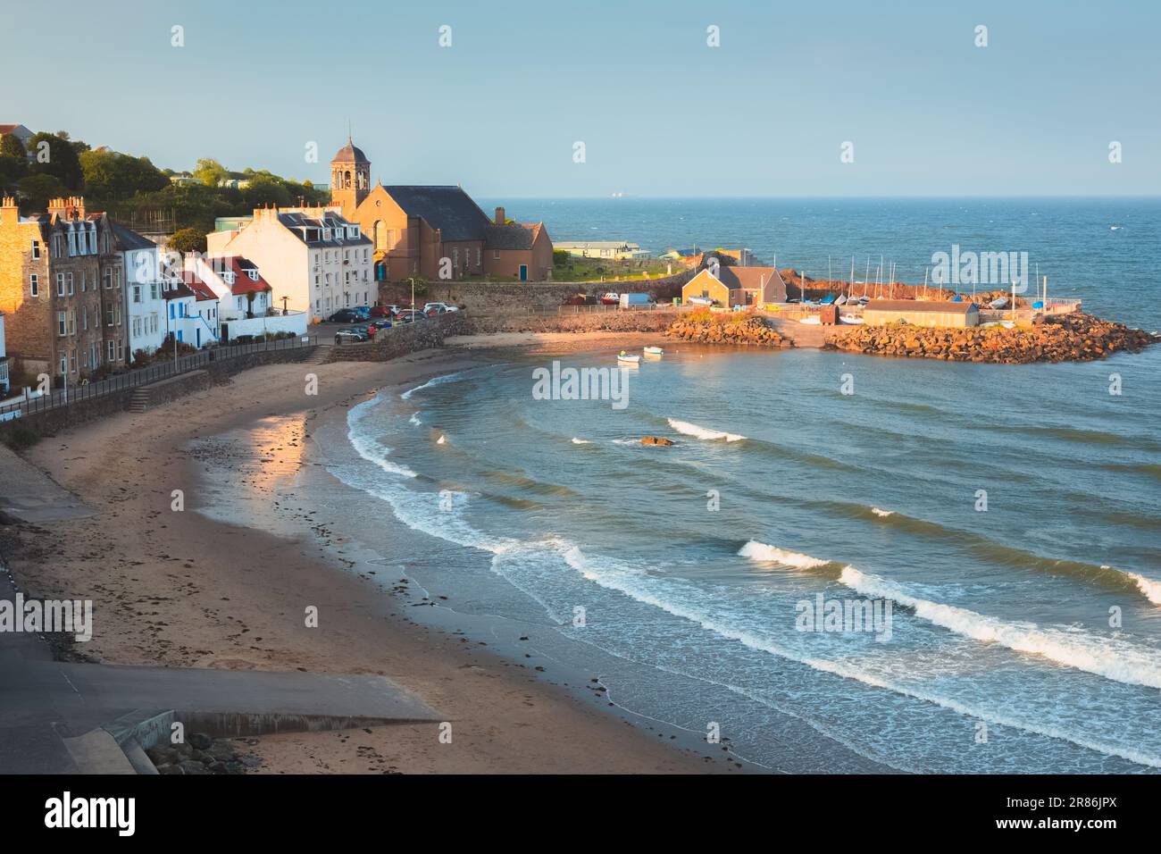 Scenic golden hour sunset view of harbour and beach at the coastal seaside fishing village of Kinghorn, Fife, Scotland, UK on a summer evening. Stock Photo