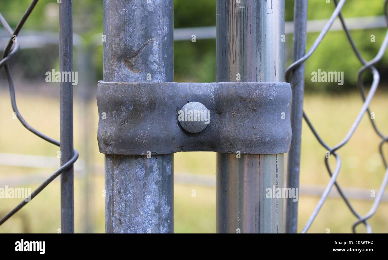 A Steel Fencing Clamp on a Chainlink Fence Corner Stock Photo