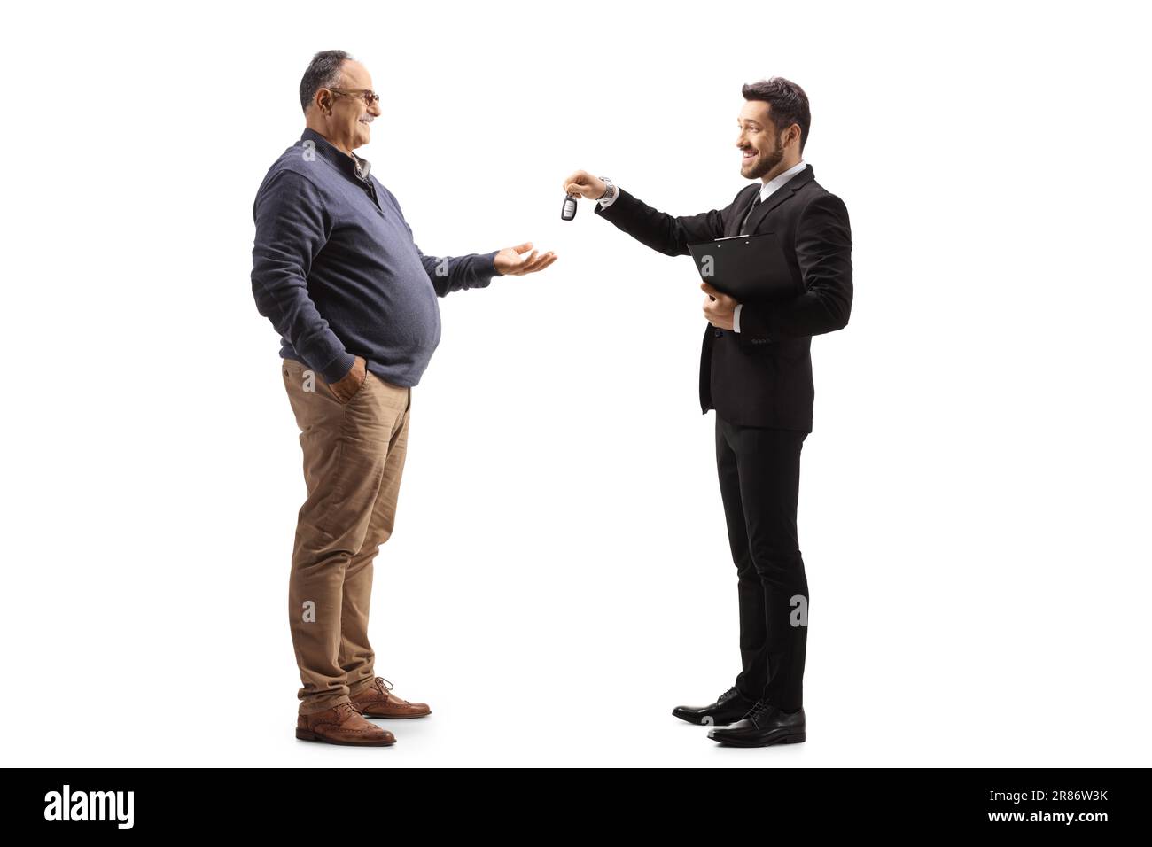 Businessman giving car keys to a mature man isolated on white background Stock Photo