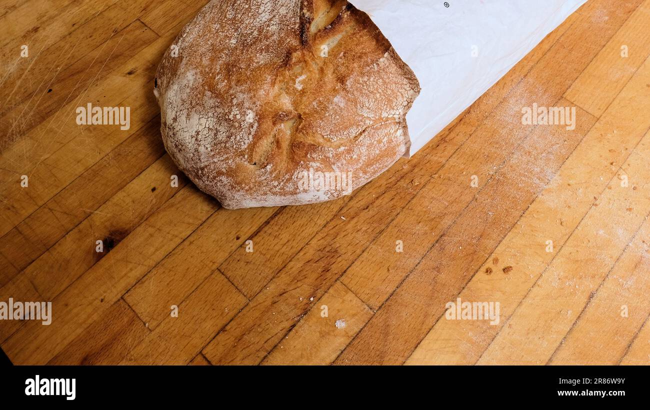 A ciabatta loaf of bread on a wooden cutting board; Italian bread. Stock Photo