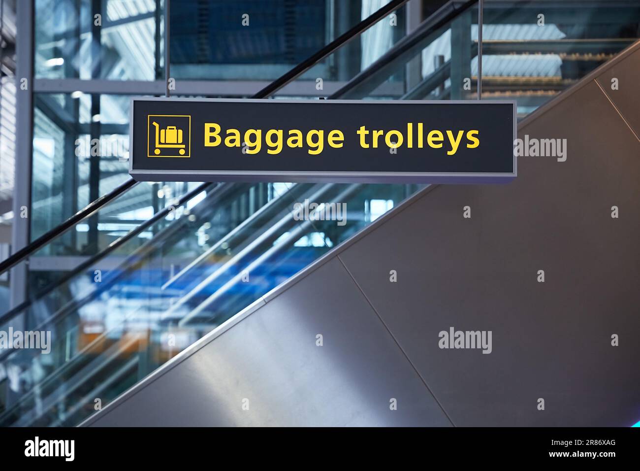 Airport terminal signs, luggage trolleys Stock Photo Alamy