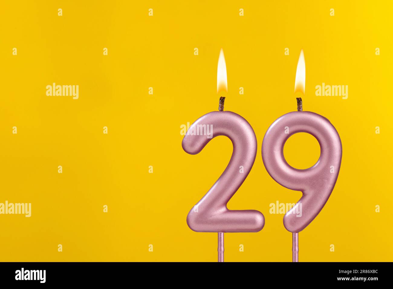 Birthday candle number 29 - Birthday celebration on yellow background Stock Photo
