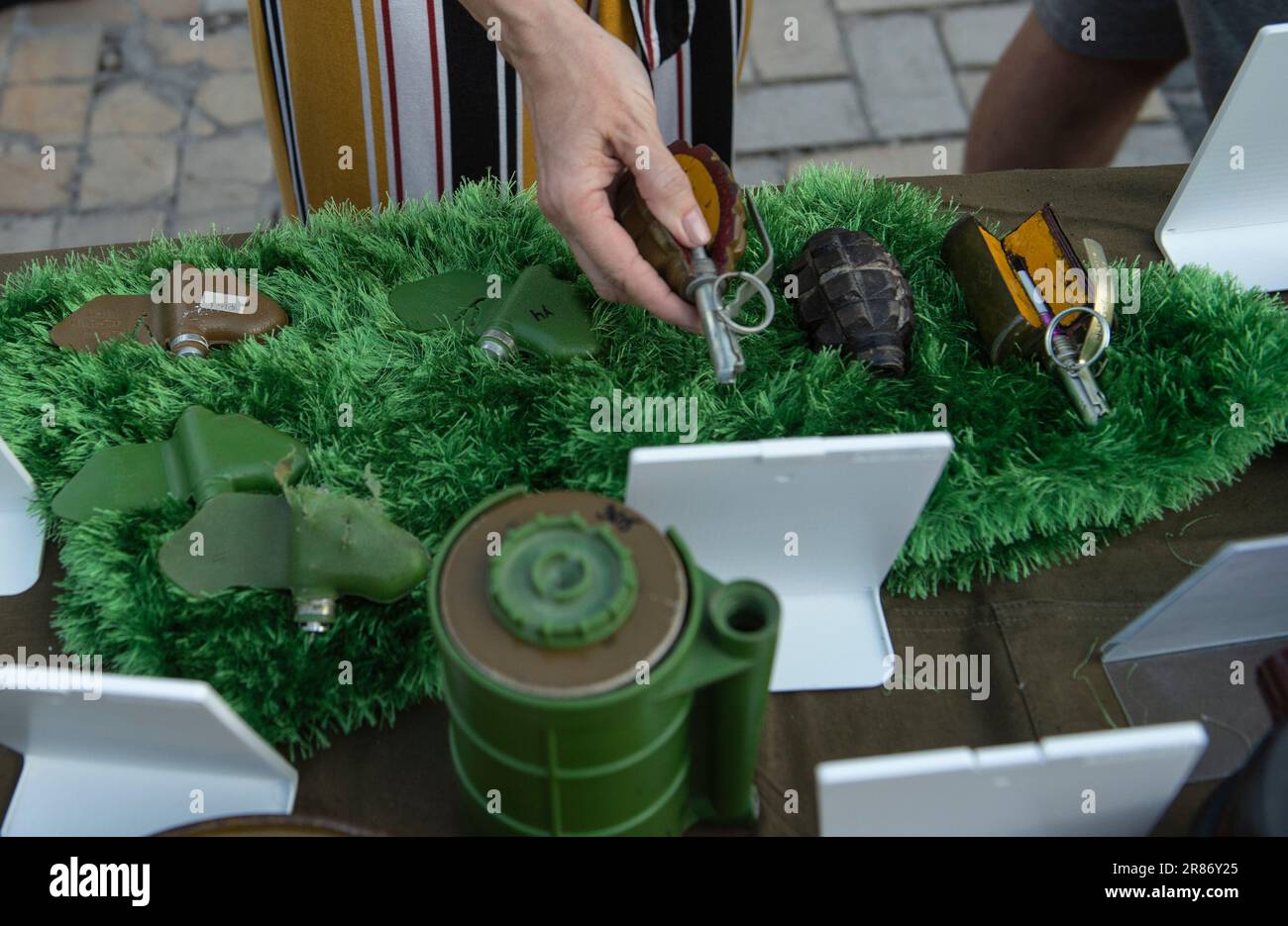 Kyiv, Ukraine. 18th June, 2023. Kyiv residents handle de-activated hand-grenades and landmines during an exhibition of Russian weaponry and equipment in Mykhailivska Square in Kyiv. Recovered Russian military equipment was put on display for residents of Kyiv to come and observe in Mykhailivska Square in Kyiv, Ukraine. The military hardware was collected from various battle fields in Ukraine by the National Museum of the Military History of Ukraine. Credit: SOPA Images Limited/Alamy Live News Stock Photo